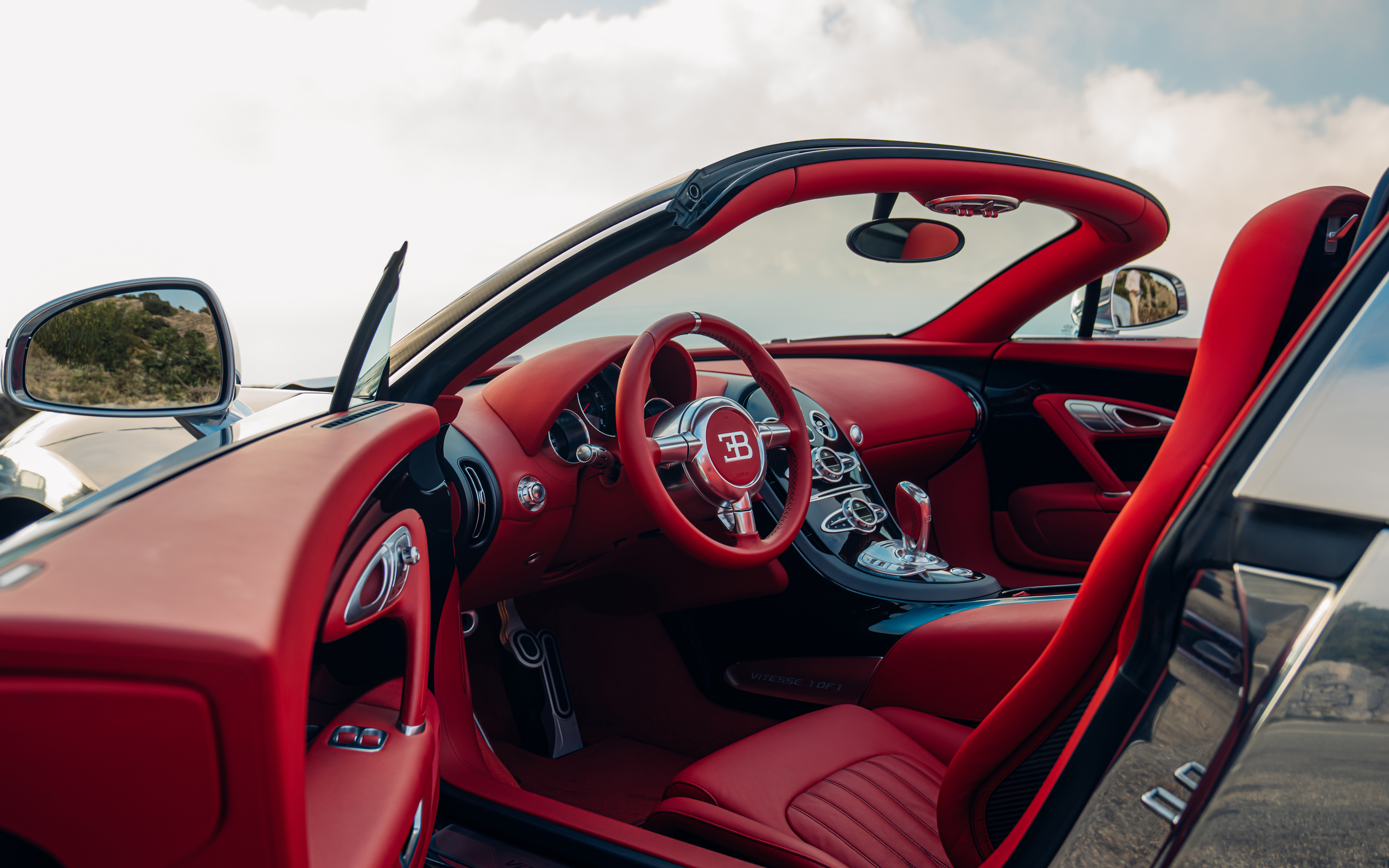 The BUGATTI VEYRON Grand Sport Vitesse sets the gleam of its polished aluminum against a ‘Carmine Red’ leather interior, offering a striking contrast.